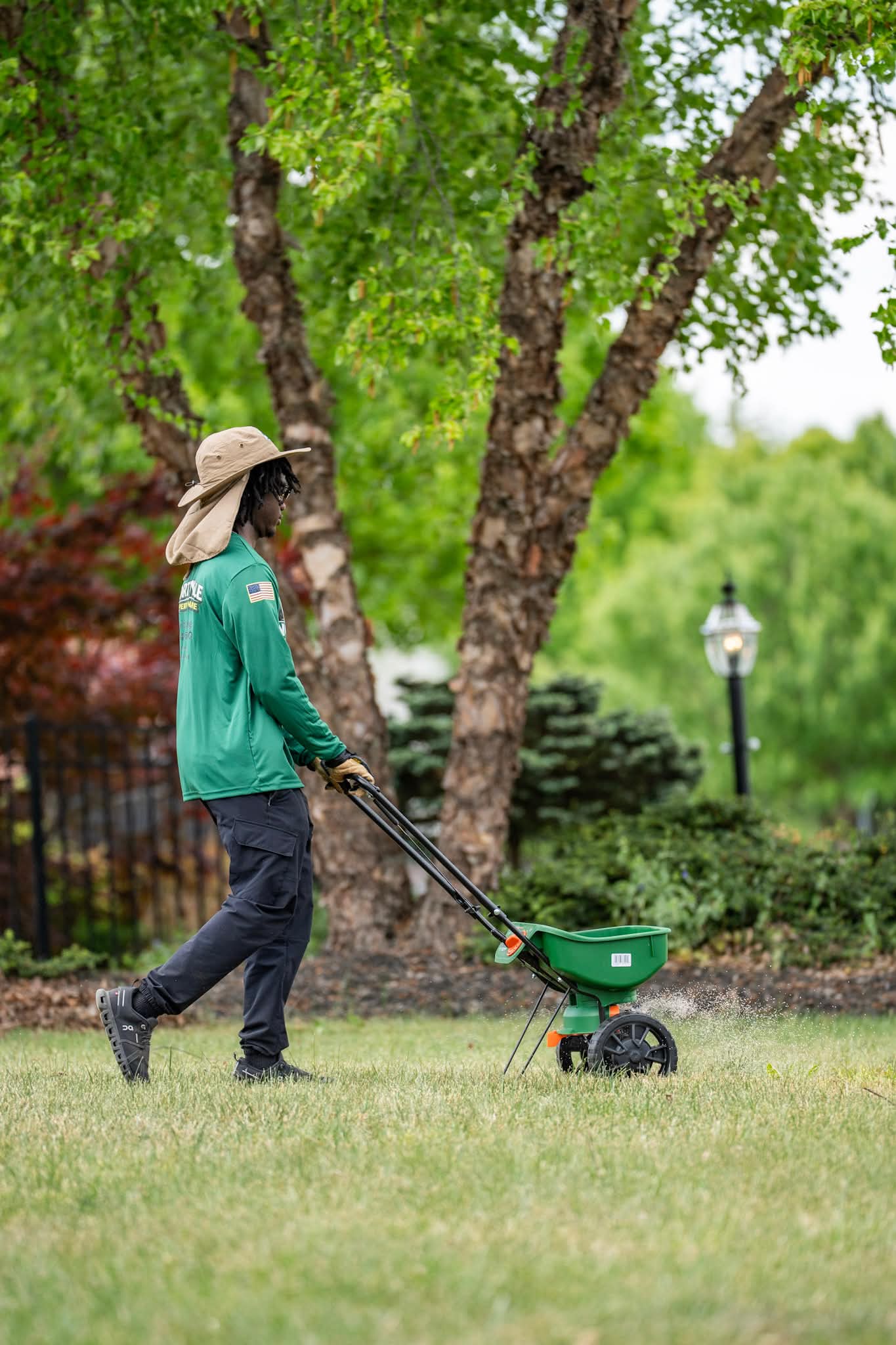 North Vale co-founder spreading seed on a manicured lawn